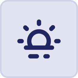 Dark blue icon of a sun partially rising or setting over a horizon, with rays and reflections, evokes the tranquil ambiance of a Hatteras Grand Room Sunset Inn, set on a light purple square background with rounded corners.