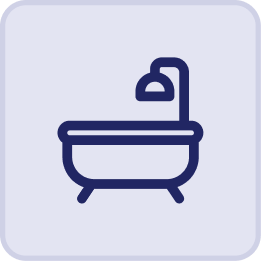 Simple icon of a bathtub with a showerhead above it, outlined in dark blue on a light background with rounded corners—perfect for capturing the relaxing vibe of the Hatteras Grand Room at Sunset Inn.